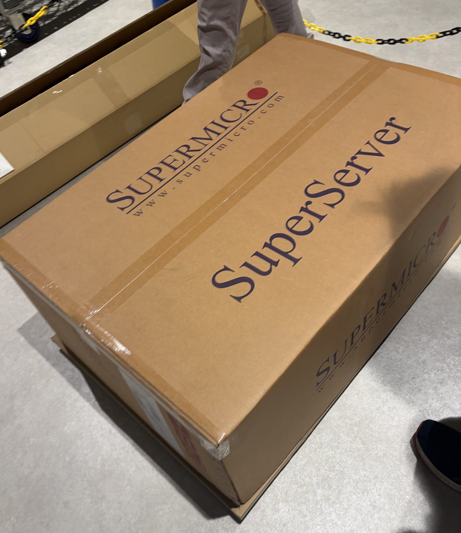 Crated server chassis on a data centre floor, shrink-wrapped as shipped.