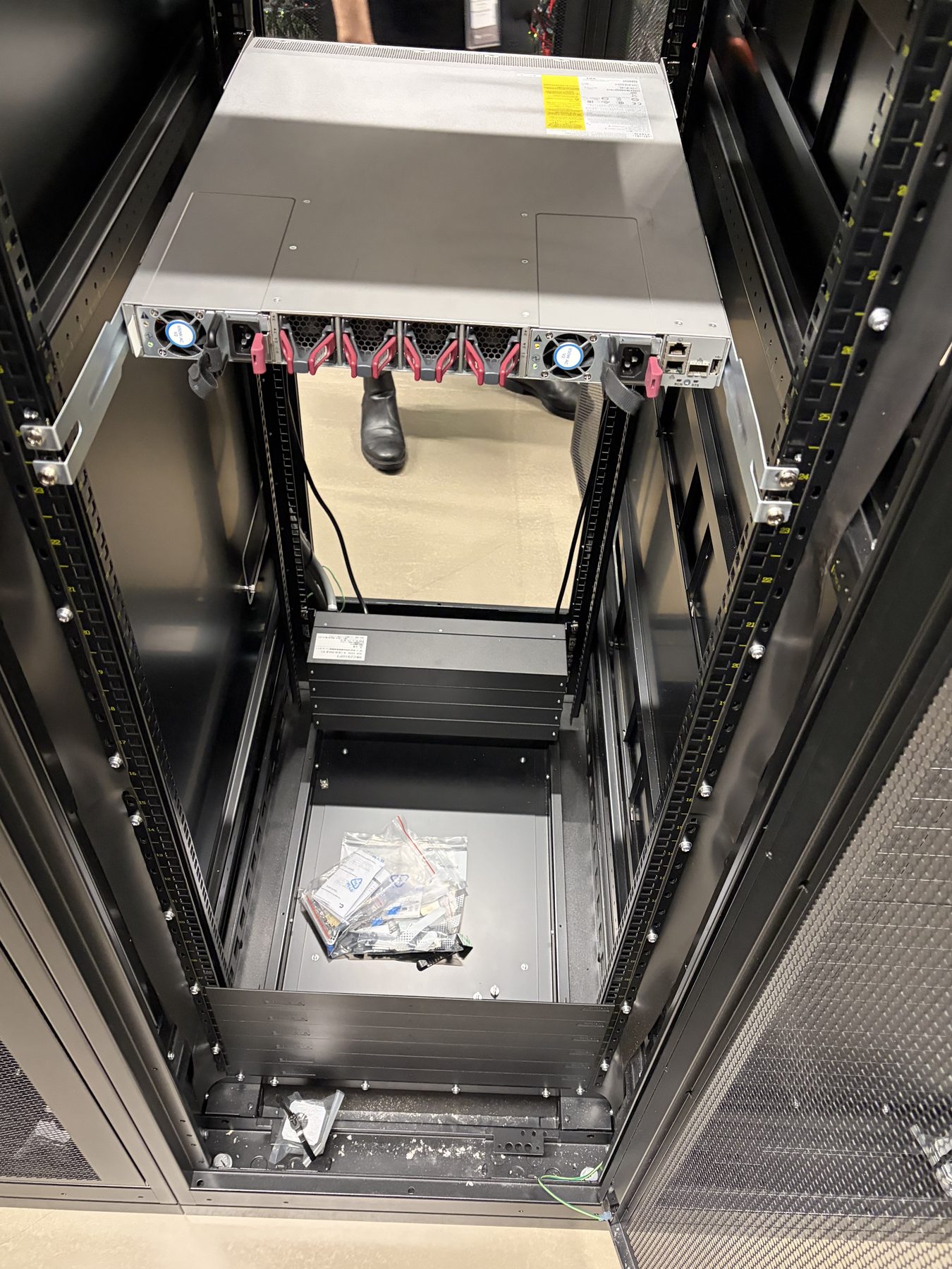 An open, almost empty rack cabinet with a single 1U switch mounted at the top.