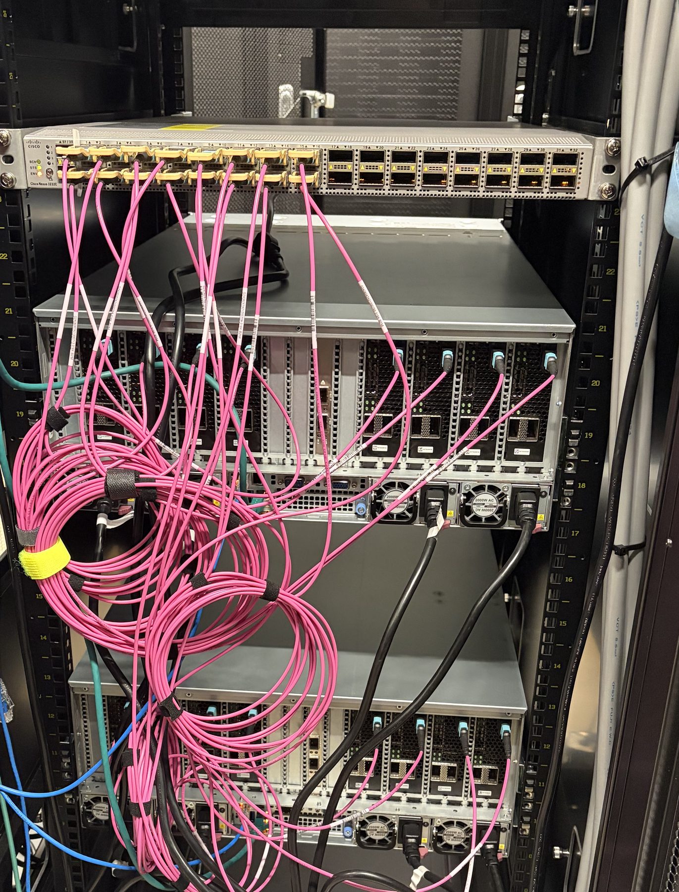 Rear of the cabinet showing fibre runs dressed between the switch and the MX8 boards.